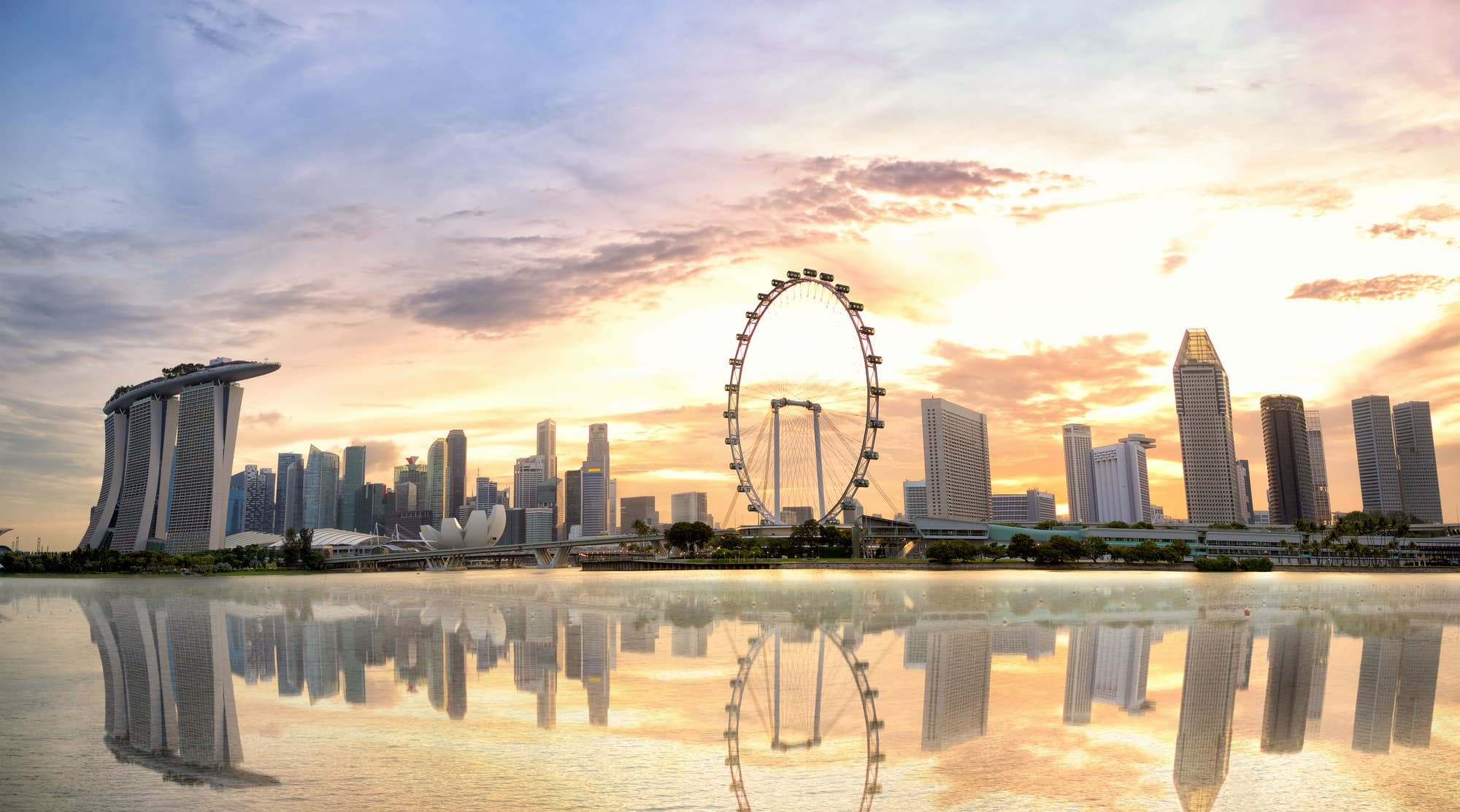 Singapore skyline at sunset across Marina Bay
